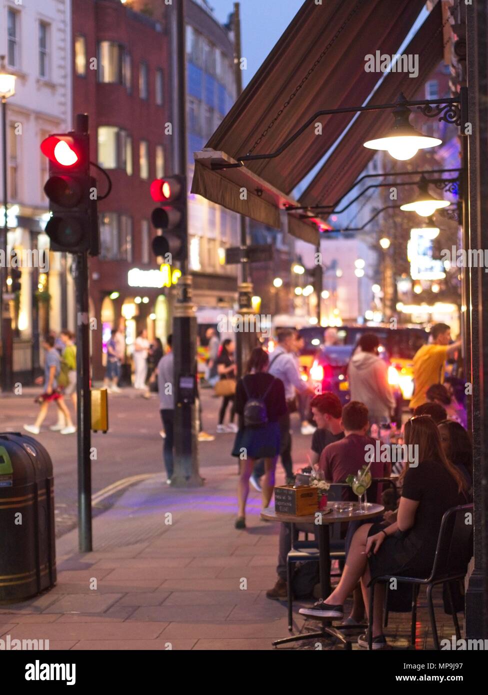 London, UK - April 16 2018: People enjoying the evening at Cafes and Bars on the busy Regent Street Stock Photo