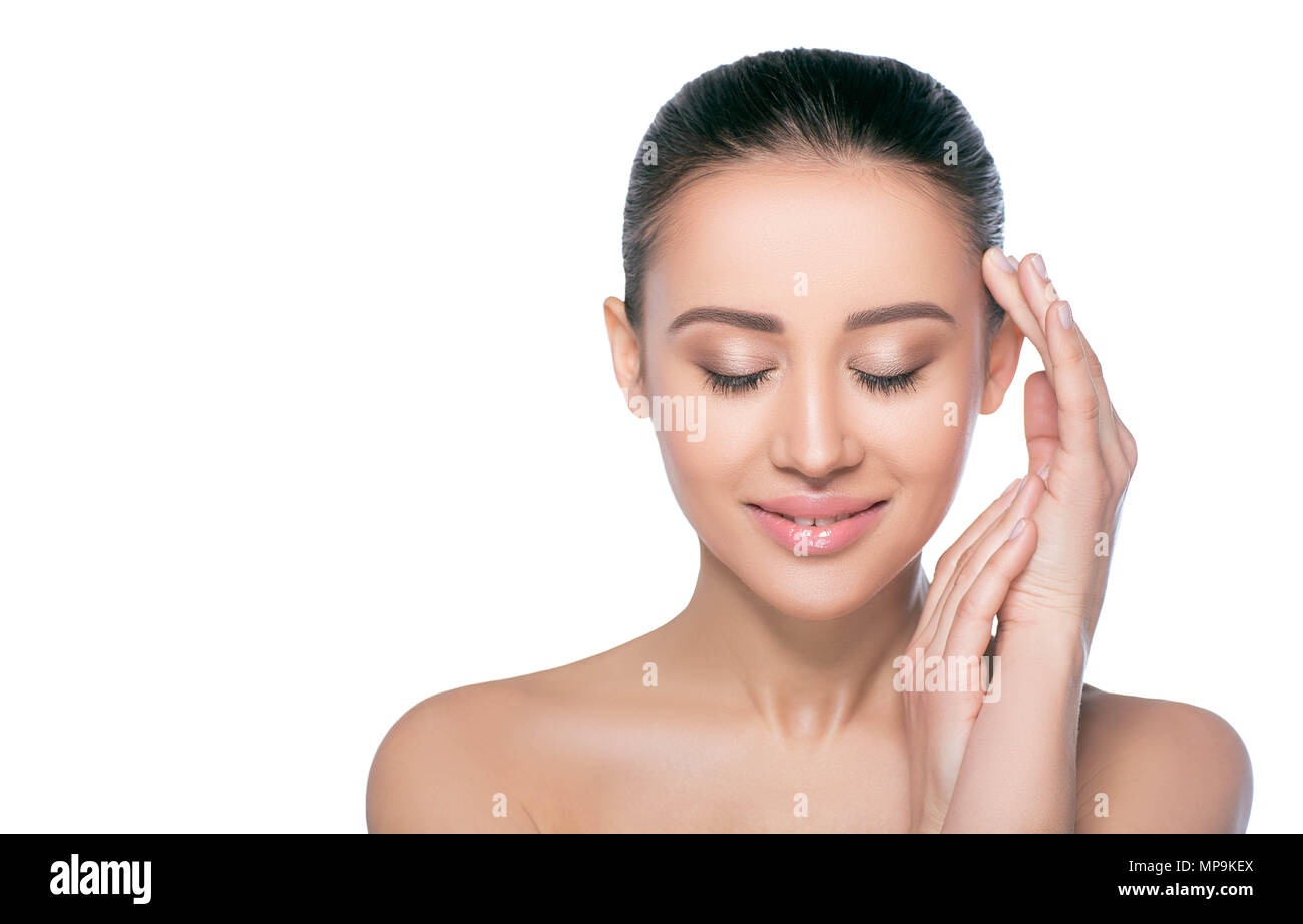 Young brunette woman smiling with closed eyes. She has natural make up on and freshness skin. Pure, all natural and fresh looking woman with perfect s Stock Photo