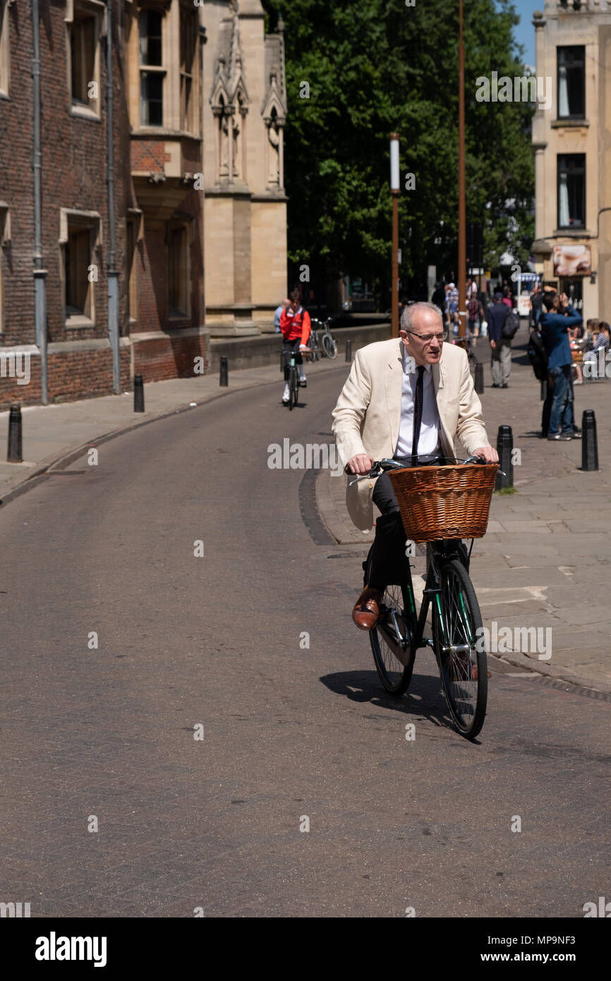 Smartly dressed older gentleman cycling in Trinity Street, Cambridge, UK. Stock Photo