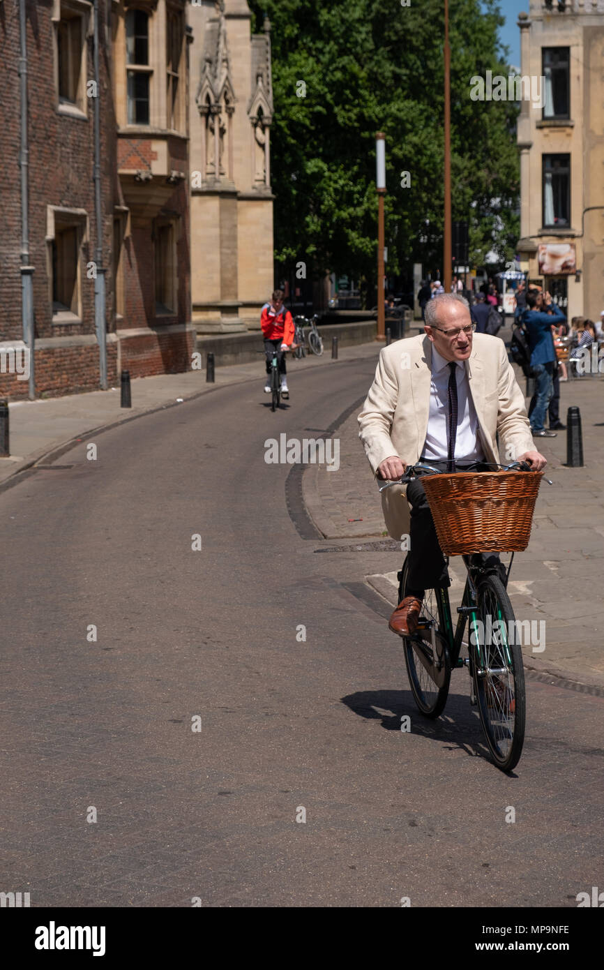 Smartly dressed older gentleman cycling in Trinity Street, Cambridge, UK. Stock Photo