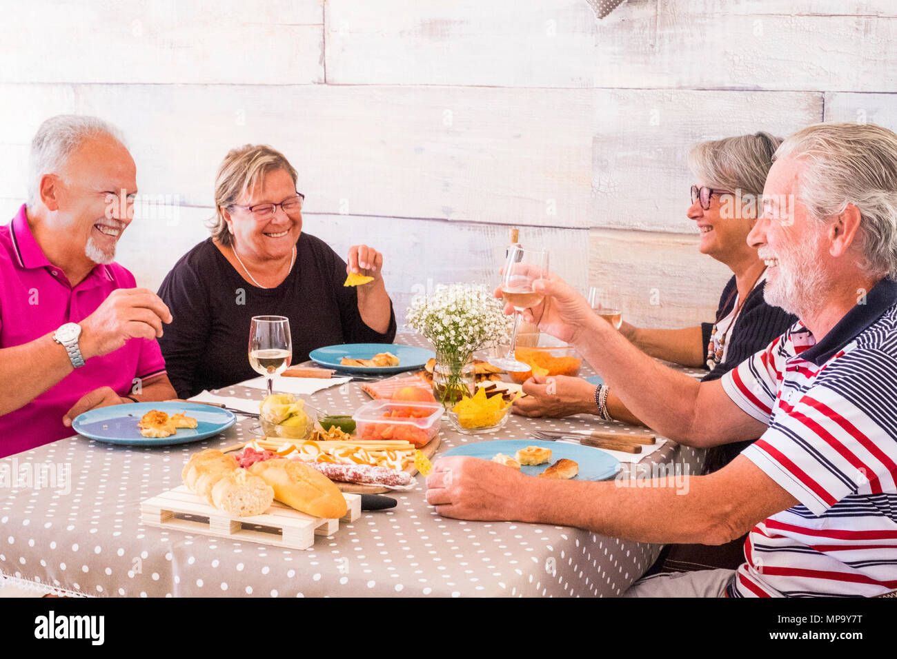 nice leisure time for group of two couples senior having lunch together with a lot of smile and laugh. friendship forever concept. Stock Photo