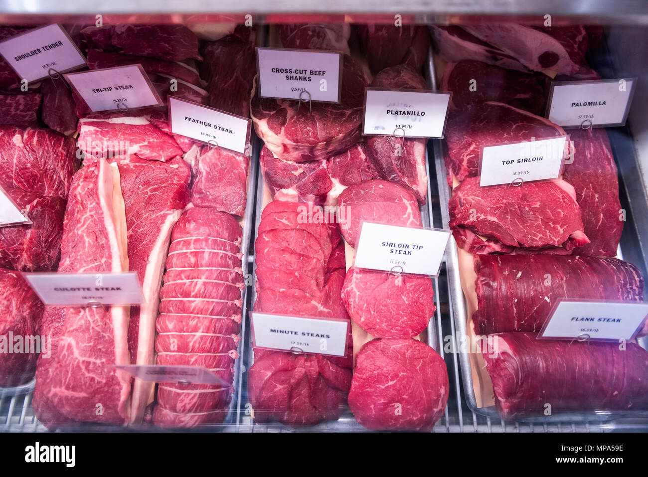 Dark red raw fatty meat boneless with fat beef steaks, in store display