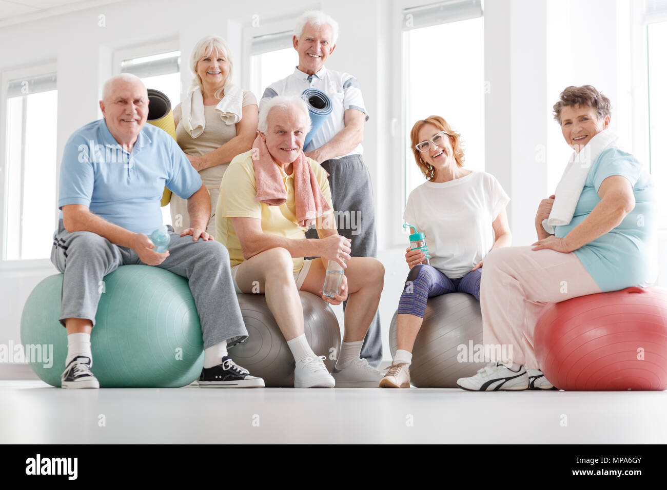 Senior fitness team resting after workout on a gym Stock Photo - Alamy