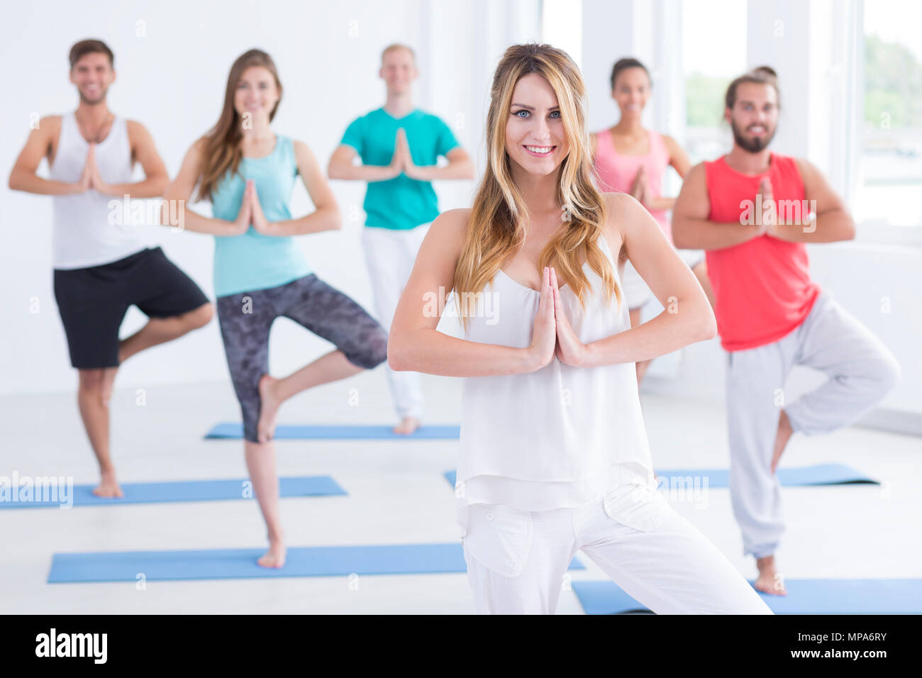 Shot of young woman instructing a group in pilates class Stock Photo