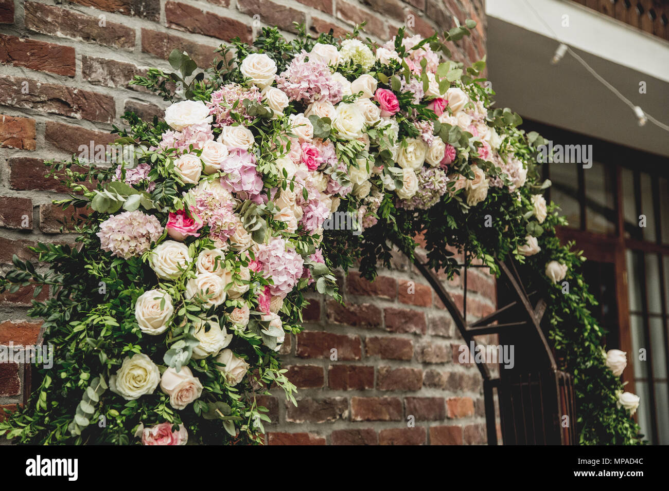 Wedding Arch Made Of Cloth And White And Pink Flowers On A Green