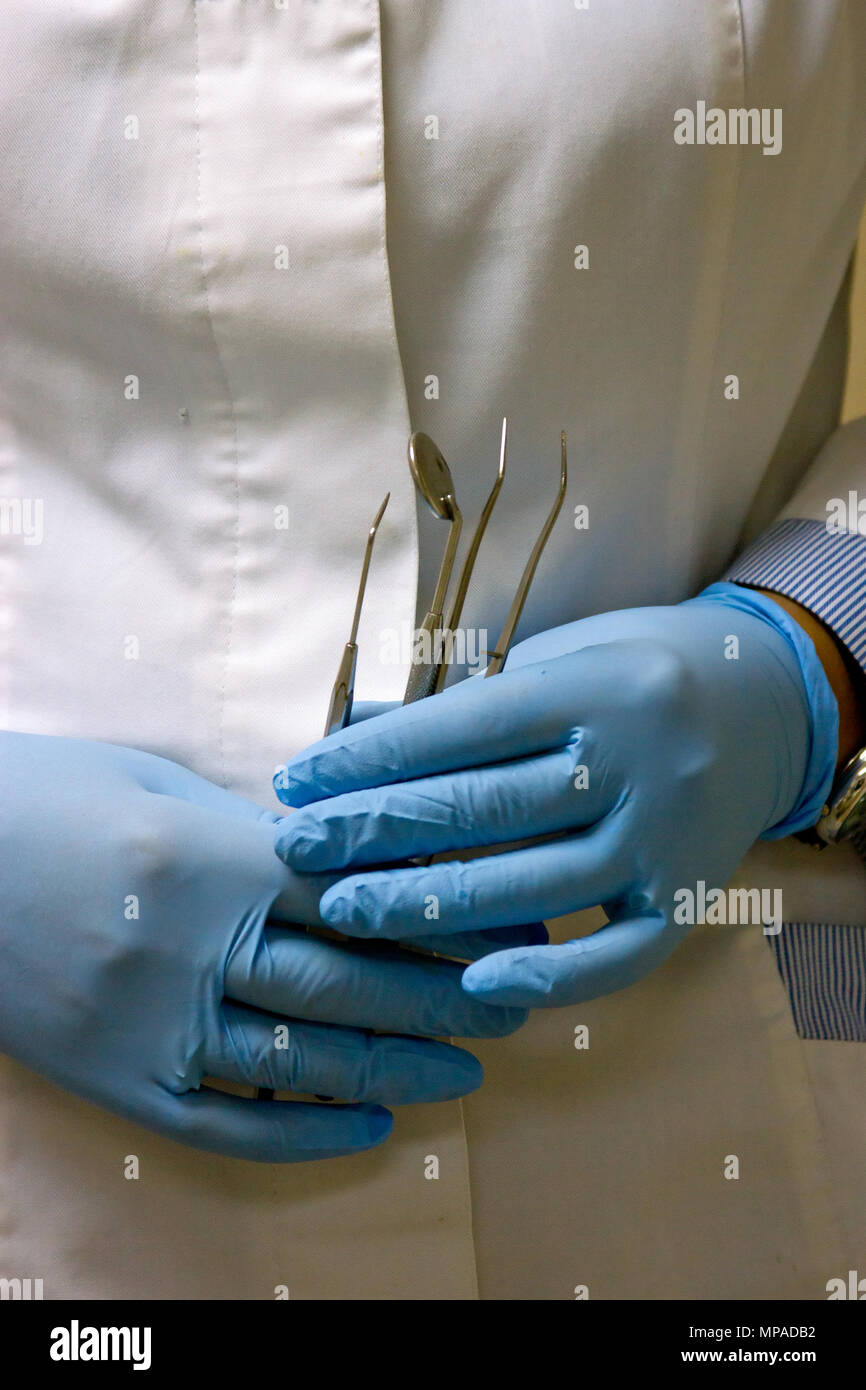 dentists hands in blue medical gloves with dental tools Stock Photo Alamy