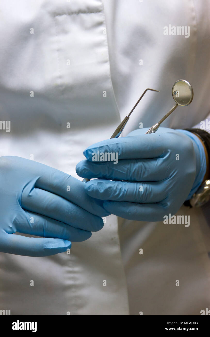 dentists hands in blue medical gloves with dental tools Stock Photo Alamy