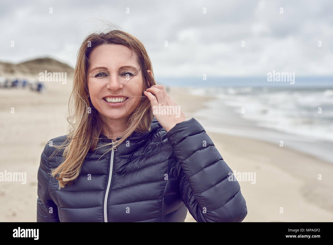 Attractive woman on a windswept beach Stock Photo