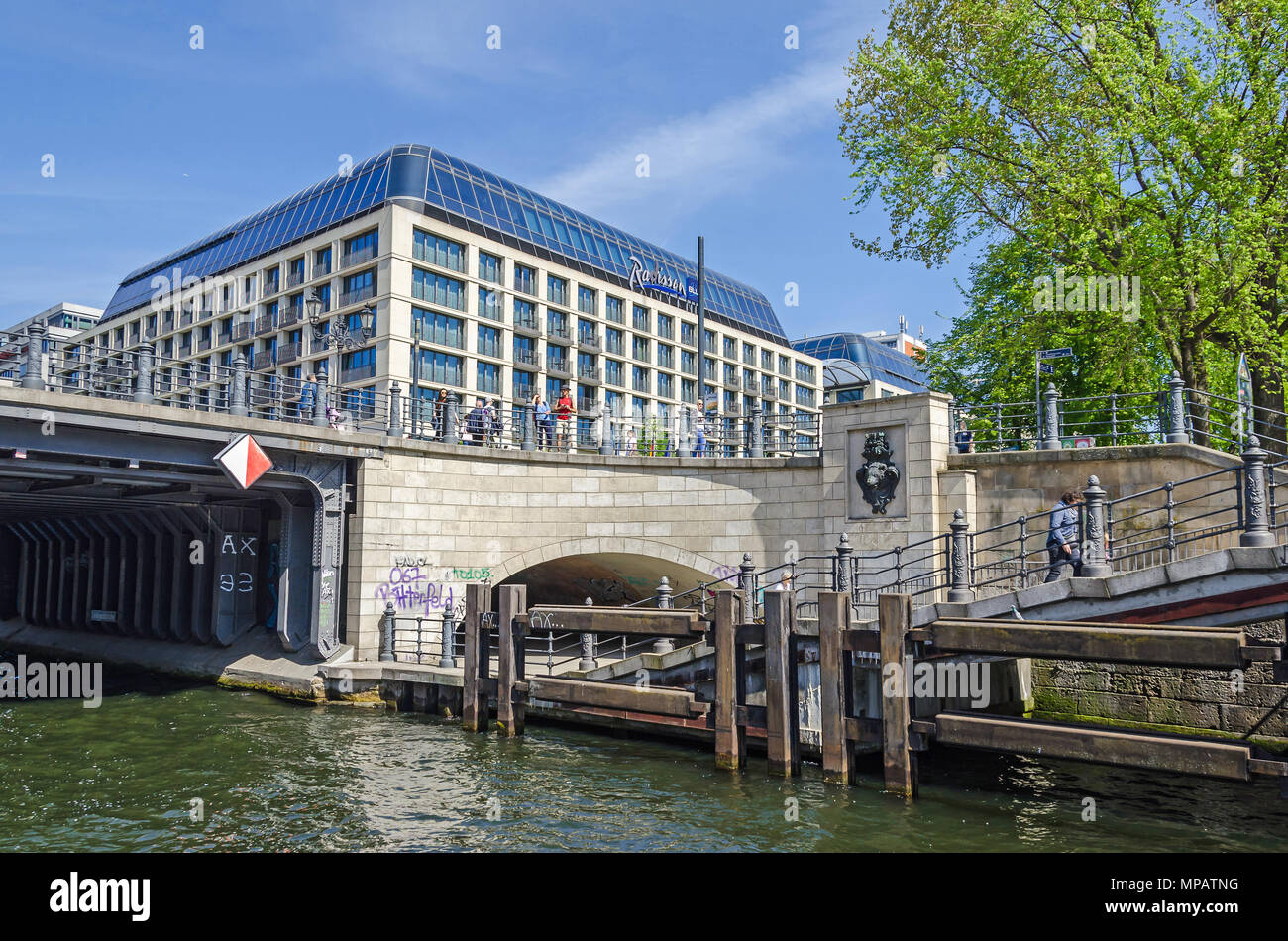 Berlin, Germany - April 22, 2018: View from the river Spree at its eastern shore, the Liebknecht bridge with its hystorical bear head and the Radisson Stock Photo