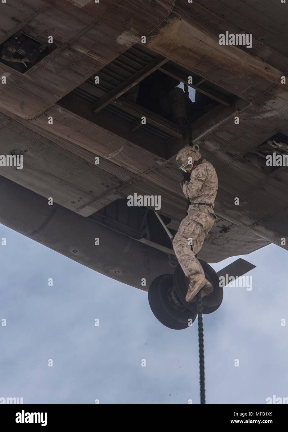 A U.S. Marine with Weapons Company, 2nd Battalion, 6th Marine Regiment, repels out of a CH-53E Super Stallion during fast rope exercise in support of Weapons and Tactics Instructors Course (WTI) 2-17 at Auxiliary Airfield II, Ariz., April 7, 2017. WTI is a seven-week training event hosted by Marine Aviation Weapons and Tactics Squadron One (MAWTS-1) cadre, which emphasizes operational integration of the six functions of Marine Corps aviation in support of a Marine Air Ground Task Force and provides standardized advanced tactical training and certification of unit instructor qualifications to s Stock Photo