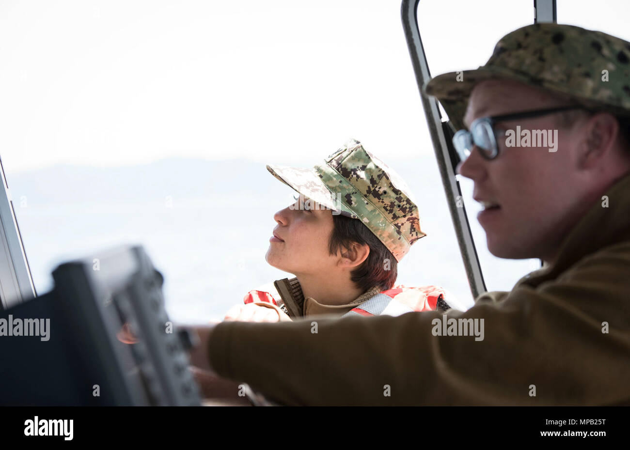 POHANG, Republic of Korea (April 7, 2017) – Hospital Corpsman 2nd Class Tyler Allen (right) and Engineman 3rd Class Giovanna Macias (left), attached to Assault Craft Unit 1, watch crafts being lowered from USNS Pililaau (T-AKR 304) during Operation Pacific Reach Exercise 2017 (OPRex17). OPRex17 is a bilateral training event designed to ensure readiness and sustain the ROK-U.S. Alliance by exercising an Area Distribution Center (ADC), an Air Terminal Supply Point (ATSP), Combined Joint Logistics Over-the-Shore (CJLOTS), and the use of rail, inland waterways, and coastal lift operations to valid Stock Photo