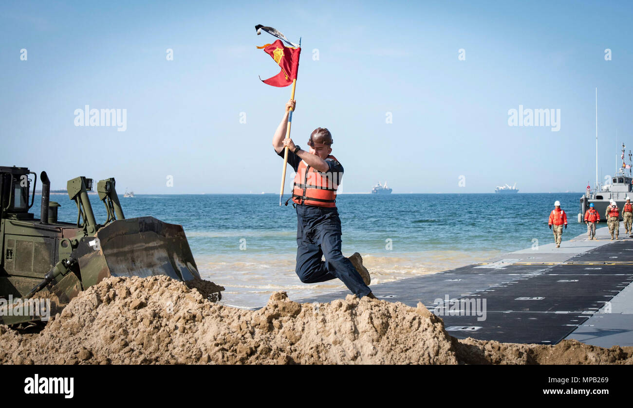 POHANG, Republic of Korea (April 7, 2017) – Spc. Joshua Garcia, attached to 331st Transportation Company, plants the command’s flag into the beach after successfully landing the Trident Pier during Operation Pacific Reach Exercise 2017 (OPRex17). OPRex17 is a bilateral training event designed to ensure readiness and sustain the ROK-U.S. Alliance by exercising an Area Distribution Center (ADC), an Air Terminal Supply Point (ATSP), Combined Joint Logistics Over-the-Shore (CJLOTS), and the use of rail, inland waterways, and coastal lift operations to validate the operational reach concept. Stock Photo