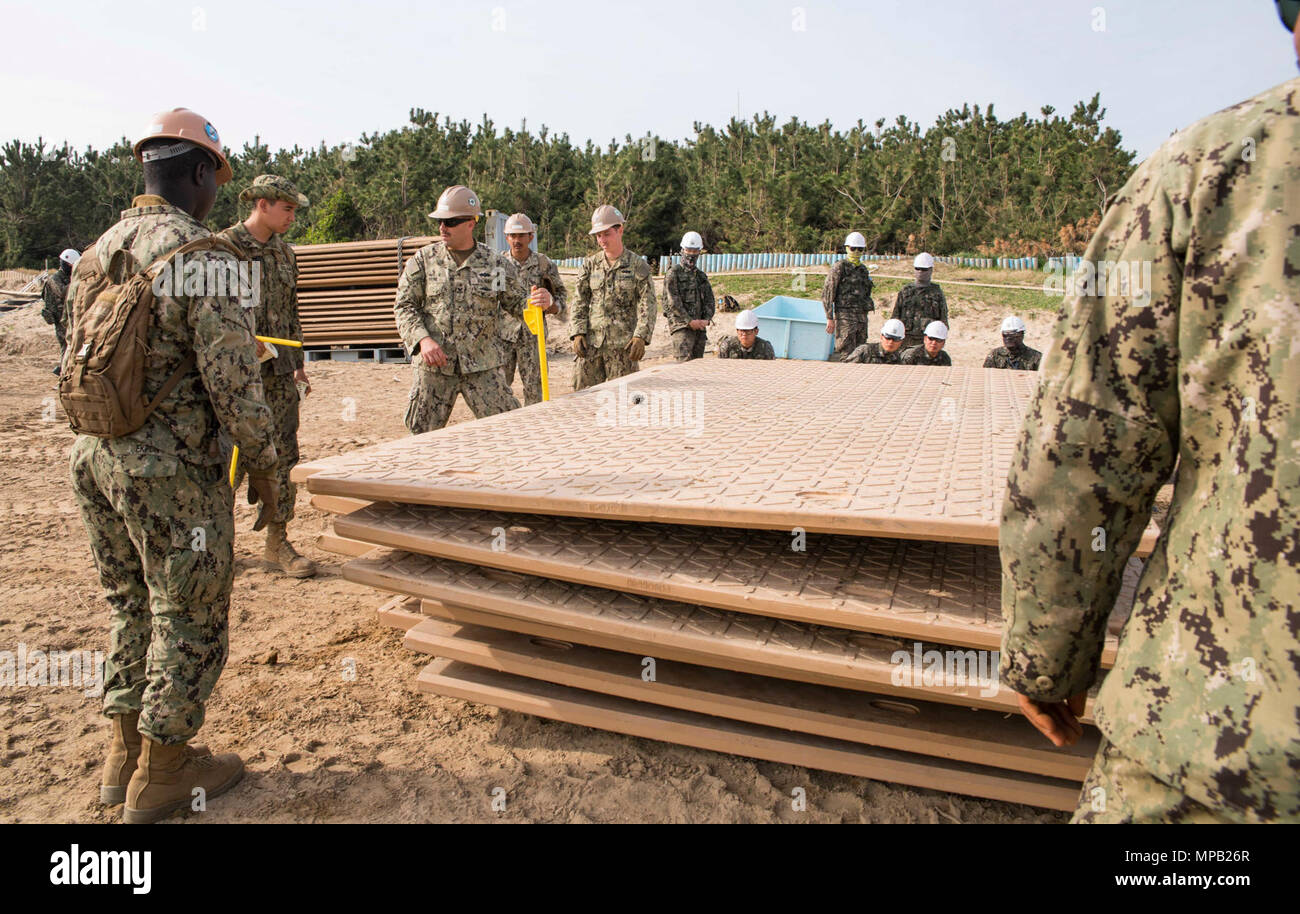 POHANG, Republic of Korea (April 8, 2017) – Seabees, attached to Amphibious Construction Battalion 1, and ROK Seabees, attached to Naval Mobile Construction Battalion 1, Naval Mobile Construction Squadron 53, learn about installing durable matting during Operation Pacific Reach Exercise 2017 (OPRex17). OPRex17 is a bilateral training event designed to ensure readiness and sustain the ROK-U.S. Alliance by exercising an Area Distribution Center (ADC), an Air Terminal Supply Point (ATSP), Combined Joint Logistics Over-the-Shore (CJLOTS), and the use of rail, inland waterways, and coastal lift ope Stock Photo
