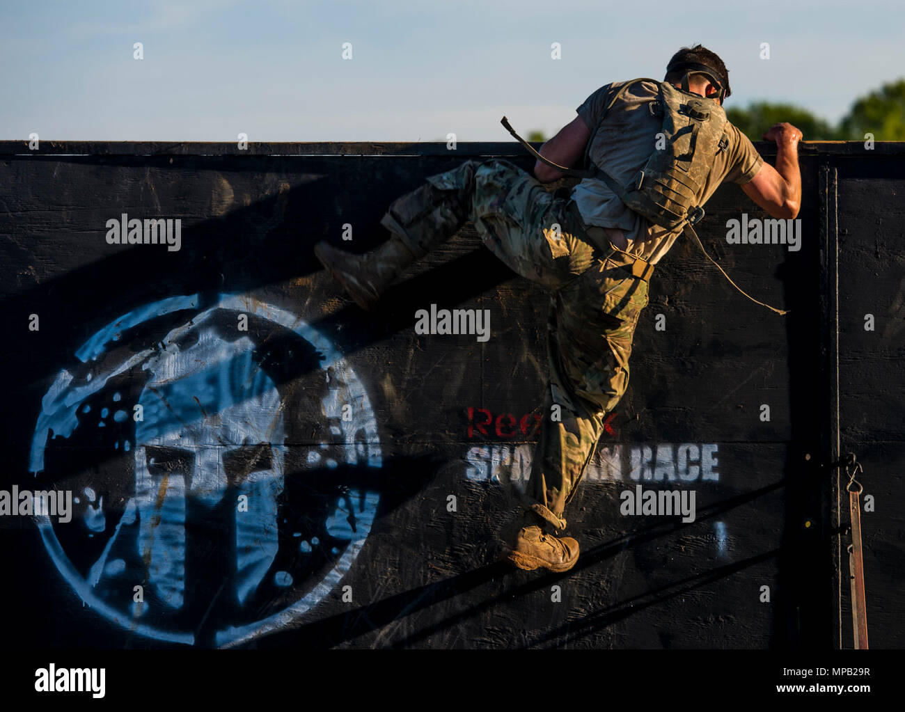 U.S. Army Rangers climb off an obstacle during a Spartan Race at the Best Ranger Competition 2017 in Fort Mitchell, Ala., April 8, 2017. The 34th annual David E. Grange Jr. Best Ranger Competition 2017 is a three-day event consisting of challenges to test competitor's physical, mental, and technical capabilities. Stock Photo