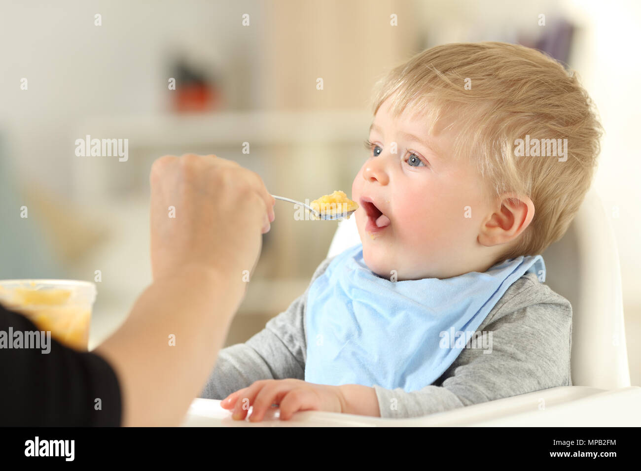 Close up of a mother hand feeding her baby at home Stock Photo
