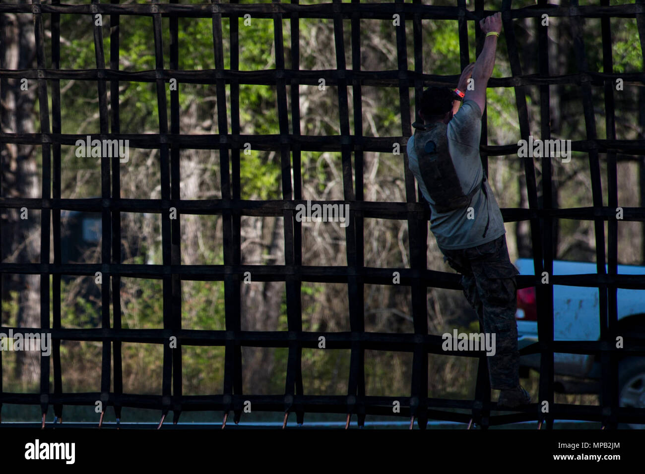 A U.S Army Ranger climbs down a rope obstacle in a Spartan Race during ...