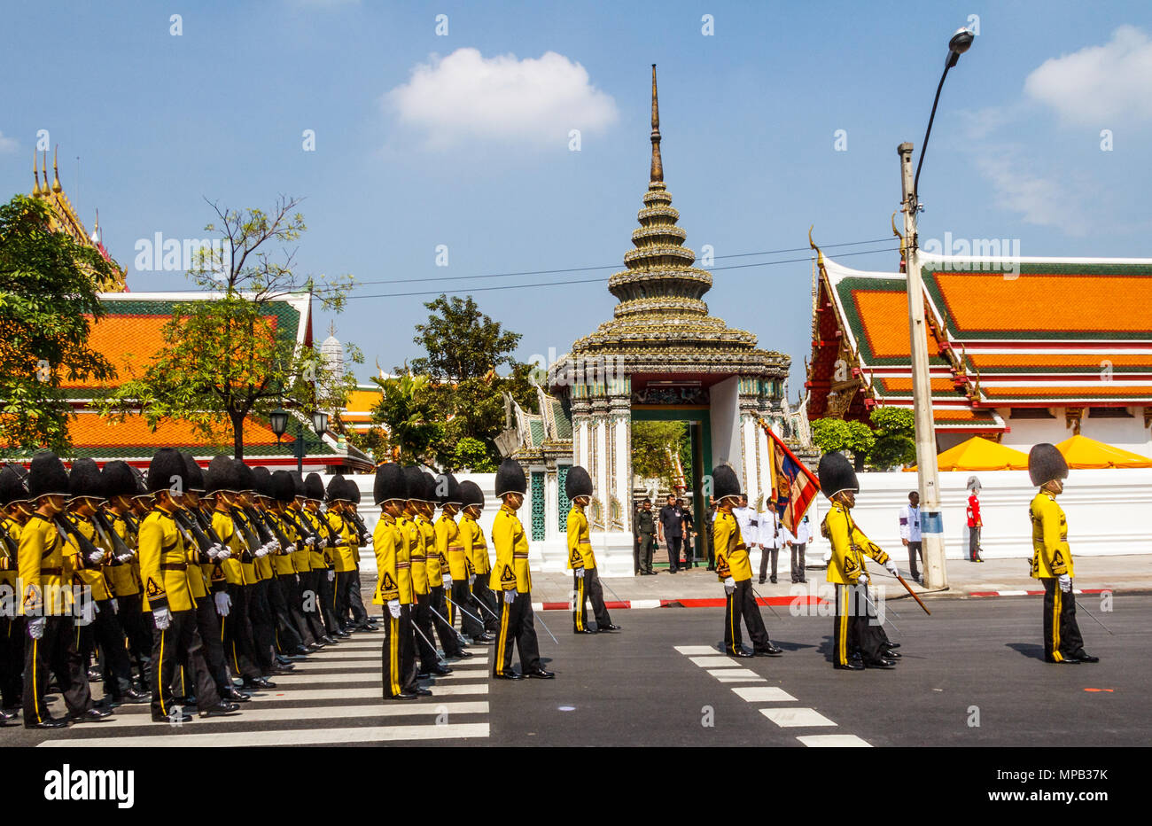 Thai soldiers in yellow uniforms on parade outside the Grand Palace, Bangkok, Thailand Stock Photo