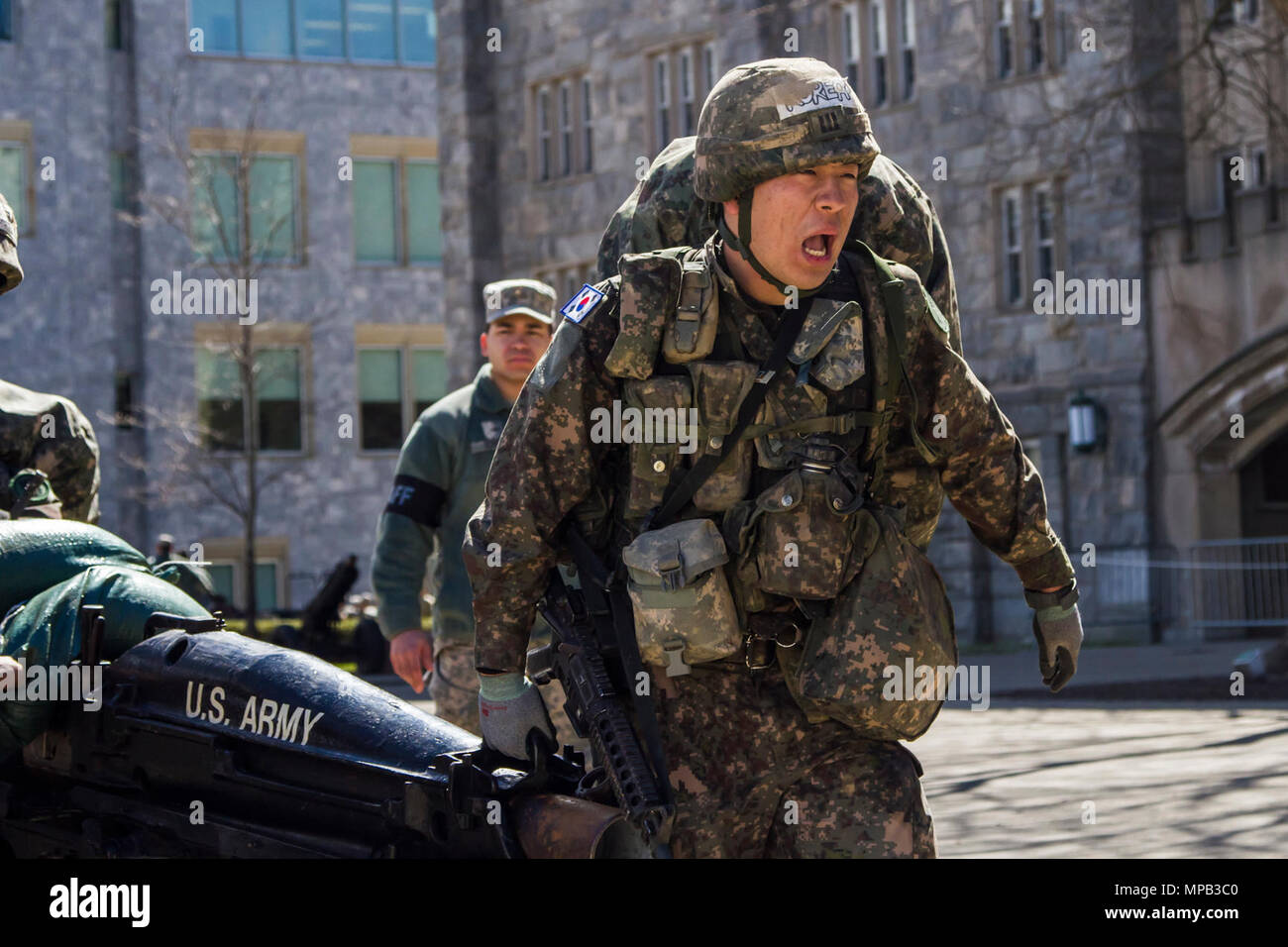 A South Korean army cadet leads his team in moving a howitzer, water cans and ammo boxes as part of the final event during the 2017 Sandhurst Military Skills Competition at the United States Military Academy, West Point, NY, April 8, 2017. During Sandhurst, 62 teams representing 12 international military academies, four U.S. service academies and eight ROTC programs competed in 11 events throughout a 23-mile course. Stock Photo