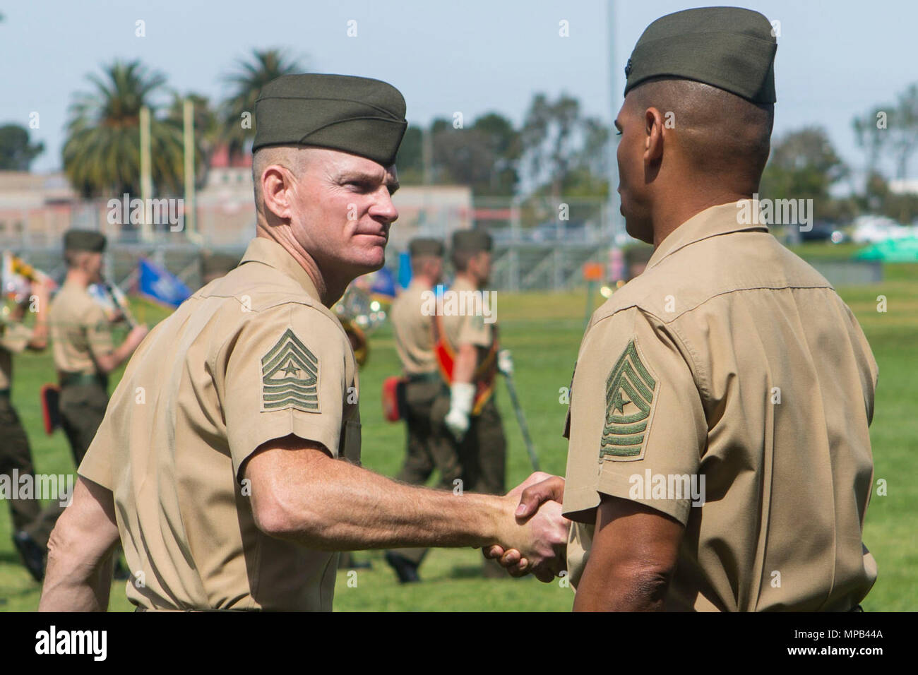 U.S. Marine Sgts. Maj.  Troy E. Black (left) and Lonnie N. Travis shake hands after the 1st Marine Logistics Group Relief and Appointment Ceremony aboard Camp Pendleton, Calif., April 7, 2017. Black relinquished his post as the sergeant major of 1st MLG to Travis during the ceremony at the 11 Area Parade Field. The ceremony included marching of the colors, passing of the sword of office, presenting Black his award and closing remarks from the oncoming and outgoing personnel. Stock Photo