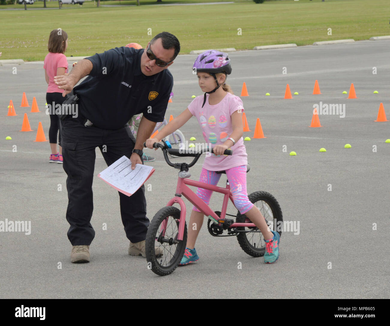 Officer Washington Moscoso, San Antonio Police Department, instructs 8-year-old Kathryn Huisken on how to start and what to do in the obstacle course at the 2017 Spring Bike Rodeo on April 8 at Joint Base San Antonio-Fort Sam Houston. Parents and children were shown a safety video by the San Antonio Police Department before riding their bikes. SAPD Officers and Explorers, Bexar County Sheriff Motorcycle Traffic Controllers and the 502nd Security Forces Squadron, provided educational, encouragement and enforcement programs that support bicycling in San Antonio at the 2017 Spring Bike Rodeo. ( U Stock Photo