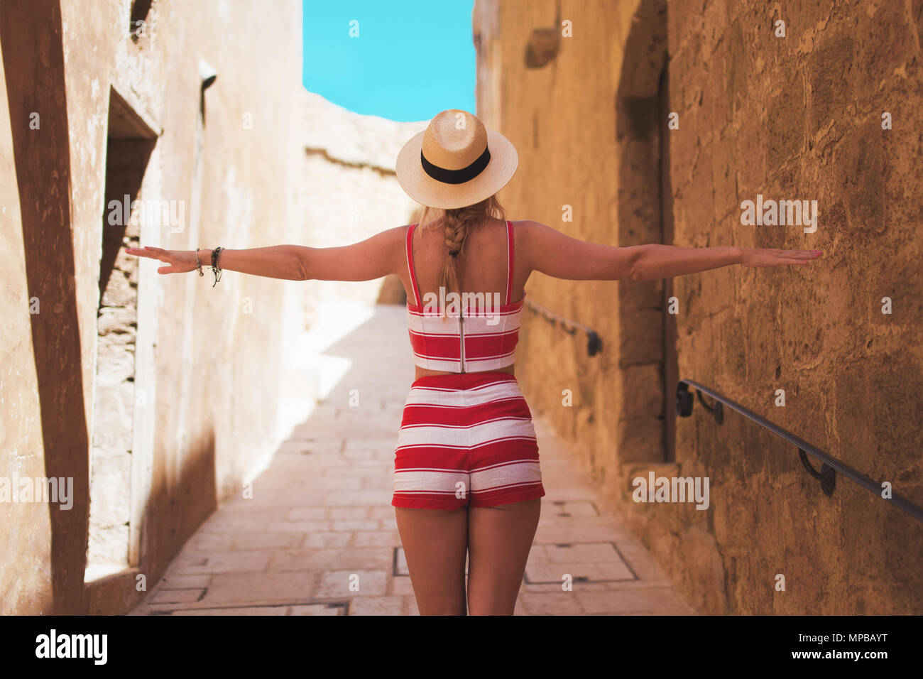 Woman in hat enjoying walking on mediterranean old street, Gozo, Malta Stock Photo