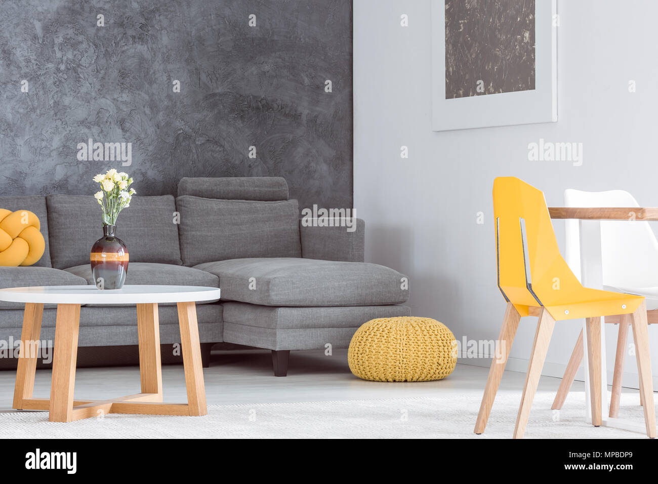 Decorative vase with flowers on wooden coffee table in living room with ...
