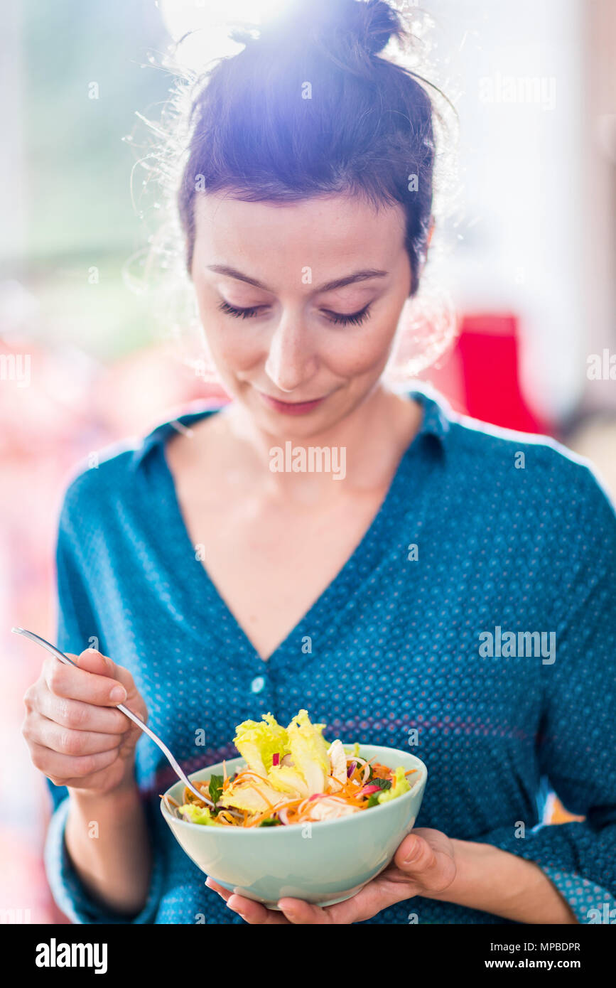Portrait of a beautiful young woman eating a salad in a bowl Stock Photo