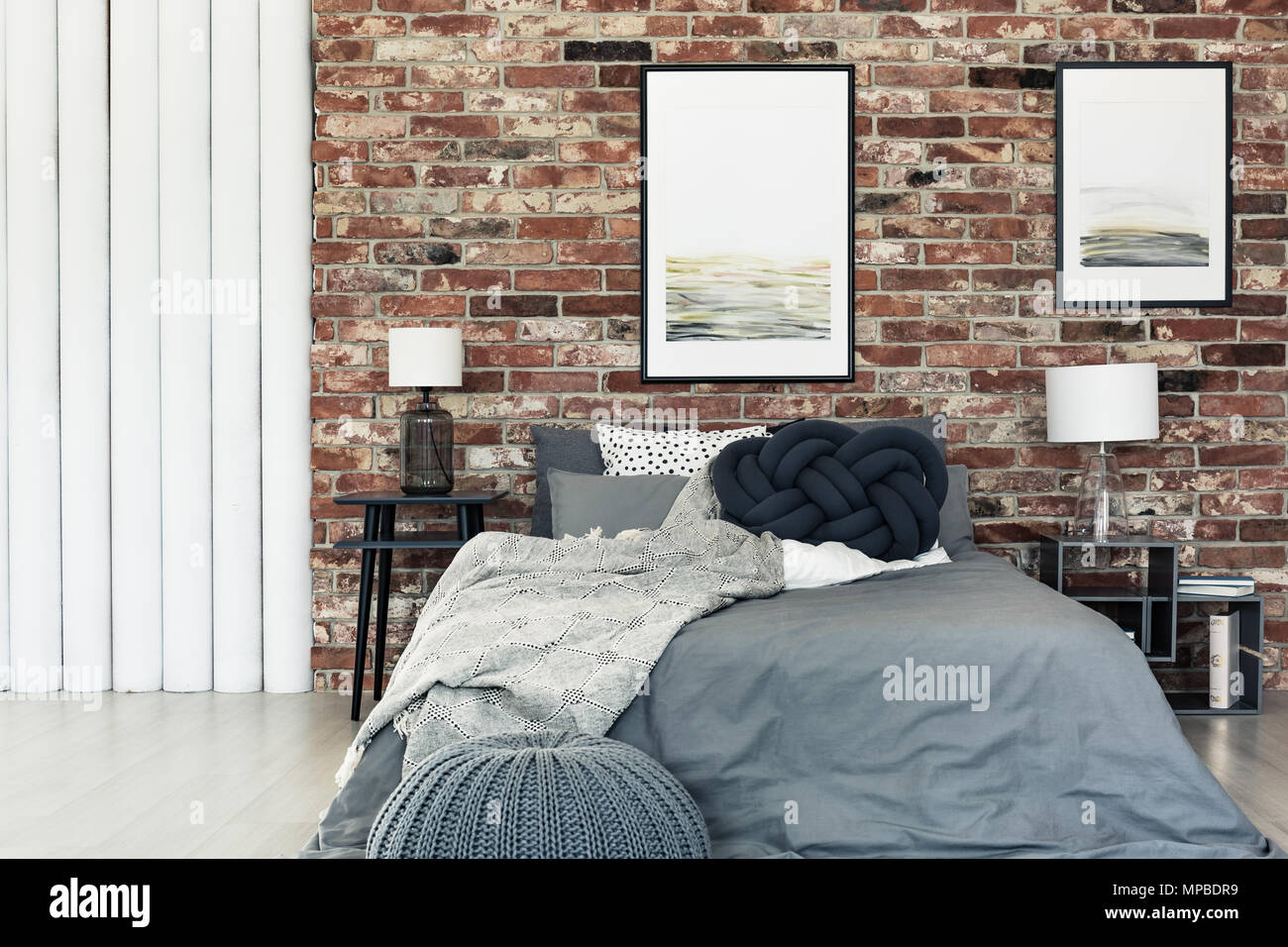 Dark knot pillow placed on a bed with grey bedding in stylish bedroom