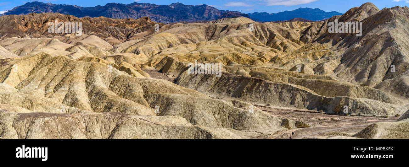 Bandlands - A panoramic midday view of eroded but colorful rolling hills, gullies and canyons in the Badlands of Death Valley National Park, CA, USA. Stock Photo