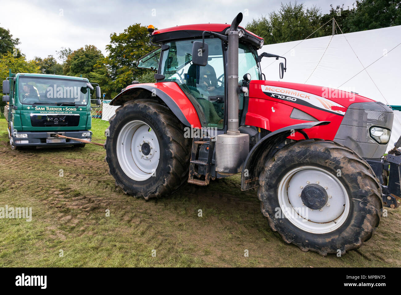 Tractor pulling a truck out of mud at Stokesley Show, North Yorkshire, England, UK Stock Photo