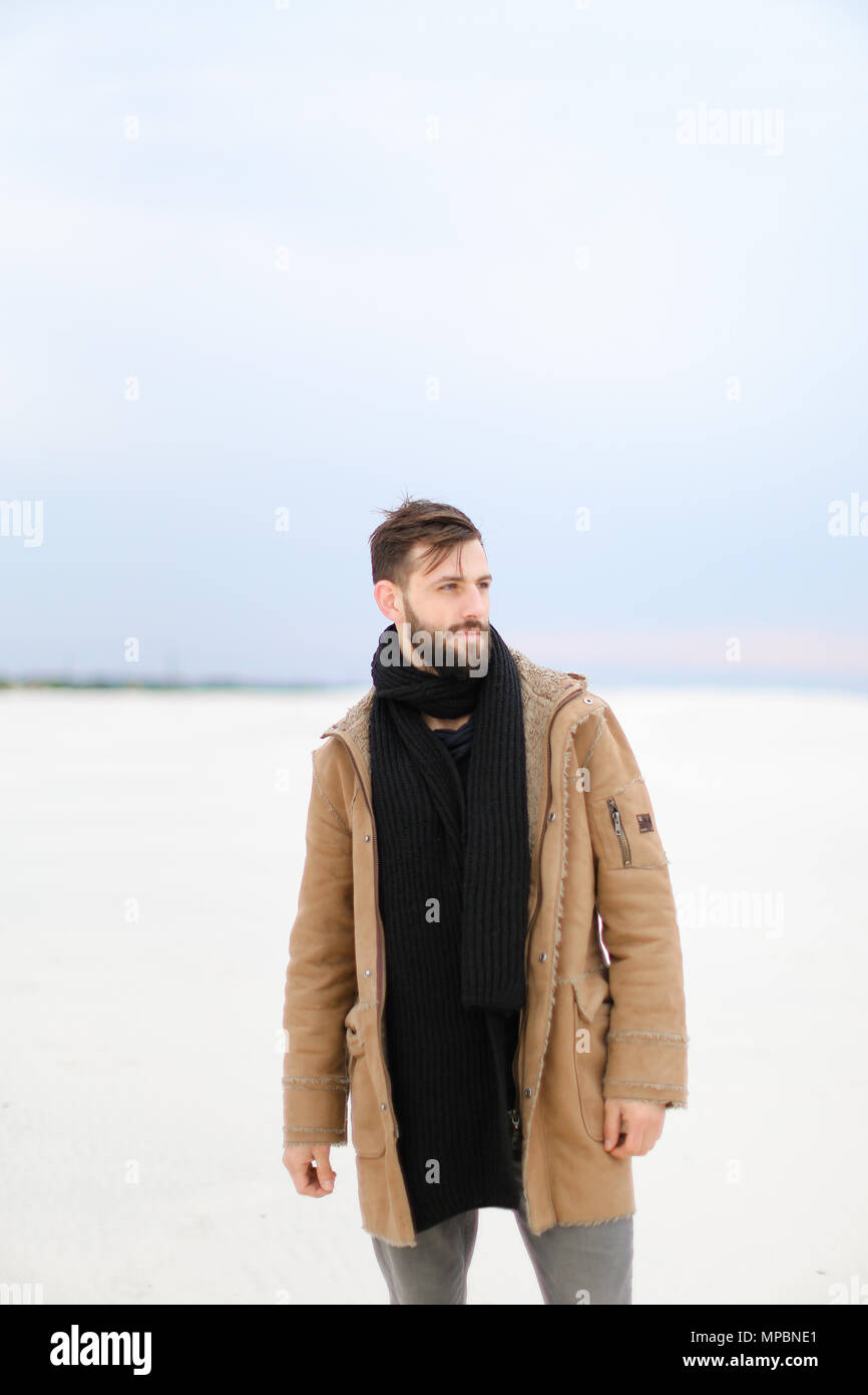 European man wearing coat and scarf standing in white snow background Stock  Photo - Alamy