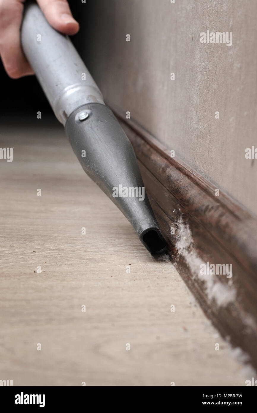 cleaning the accumulated dust with a vacuum cleaner. Woman vacuuming