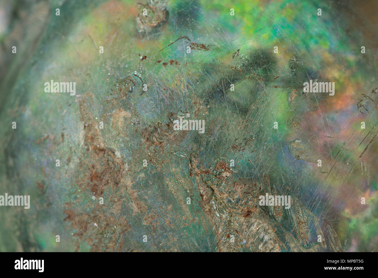 Iridescence on ancient old weathered glass, weathering on the surface, interplay of lustrous colours due to the refraction of light on thin layers Stock Photo