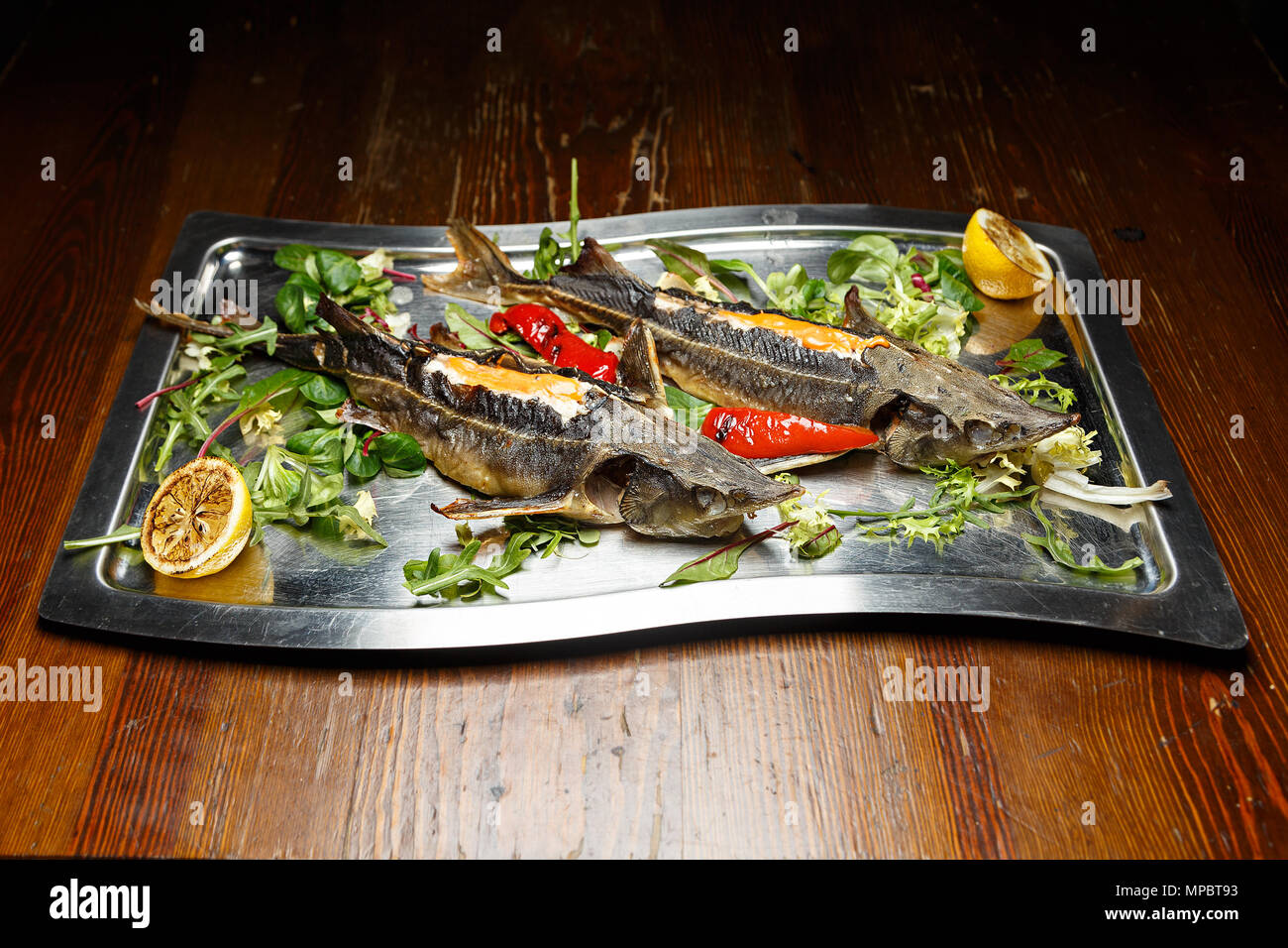 Fresh sturgeon grilled, cooked with vegetables, served with fresh herbs