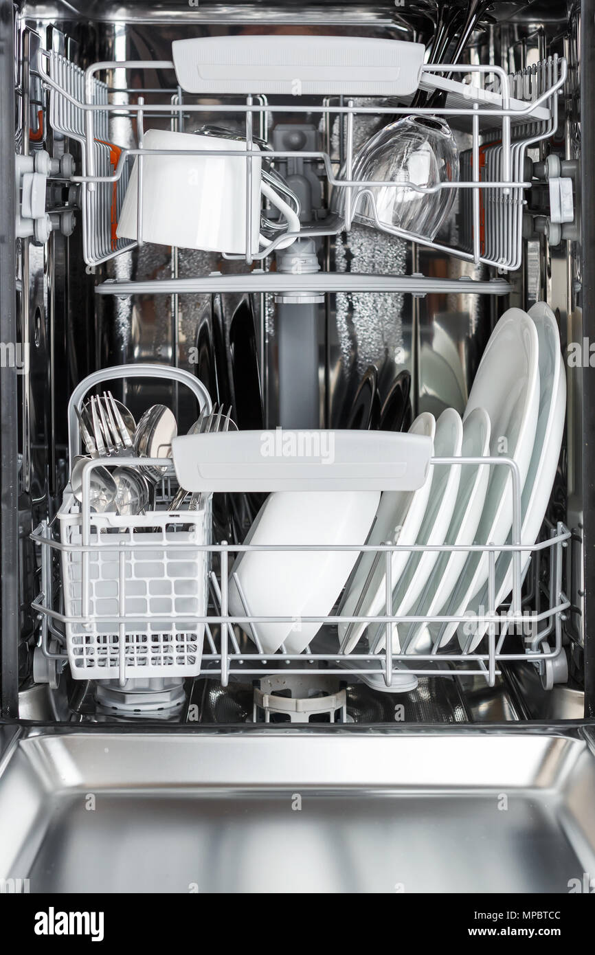 open dishwasher front view clean plates cups glasses and cutlery in the dishwasher after washing MPBTCC