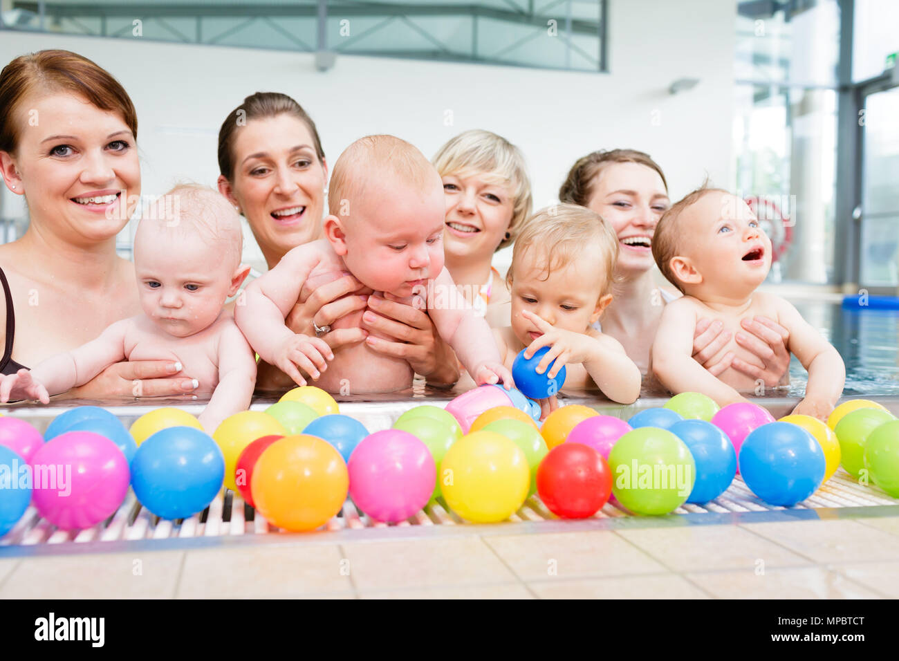 Group picture of mothers and babies at infant swimming class Stock