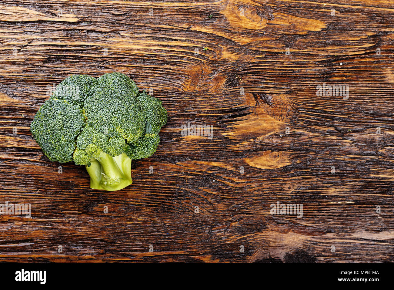 Inflorescence of raw broccoli on a wooden table, horizontal photo Stock Photo