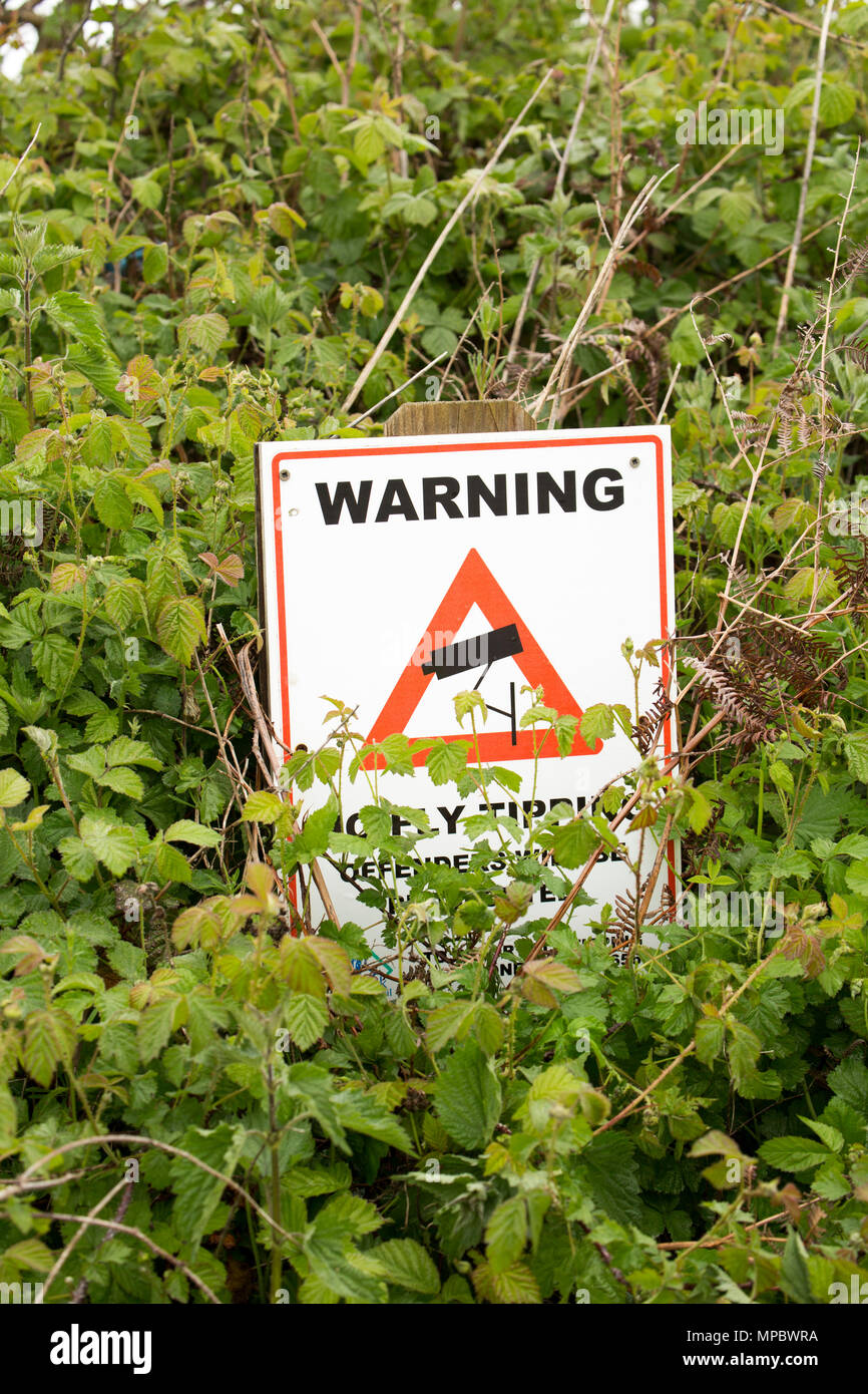A partially obscured flytipping sign warning not to leave rubbish in a layby. Dorset England UK GB Stock Photo