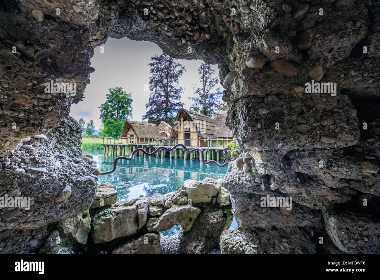 View trough a cave hole to the old straw houses in bally park schoenenwerd switzerland Stock Photo Alamy