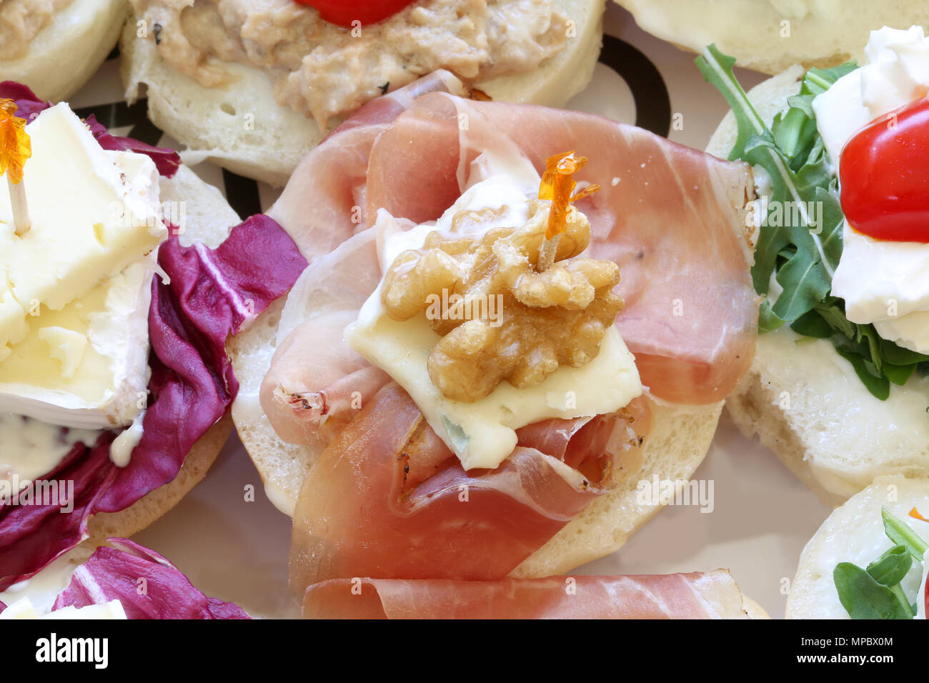 bread called canape or tartine with nut and raw ham at european party Stock Photo