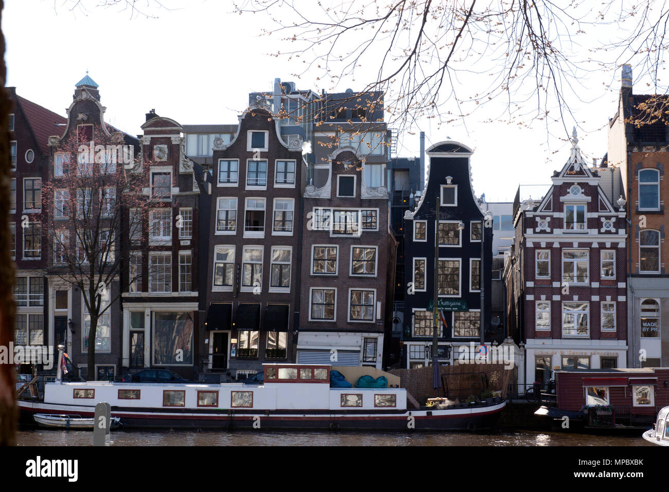 Amsterdam,The Netherlands-march 22,2015: canals houses at the river amstel l and a house boat Stock Photo