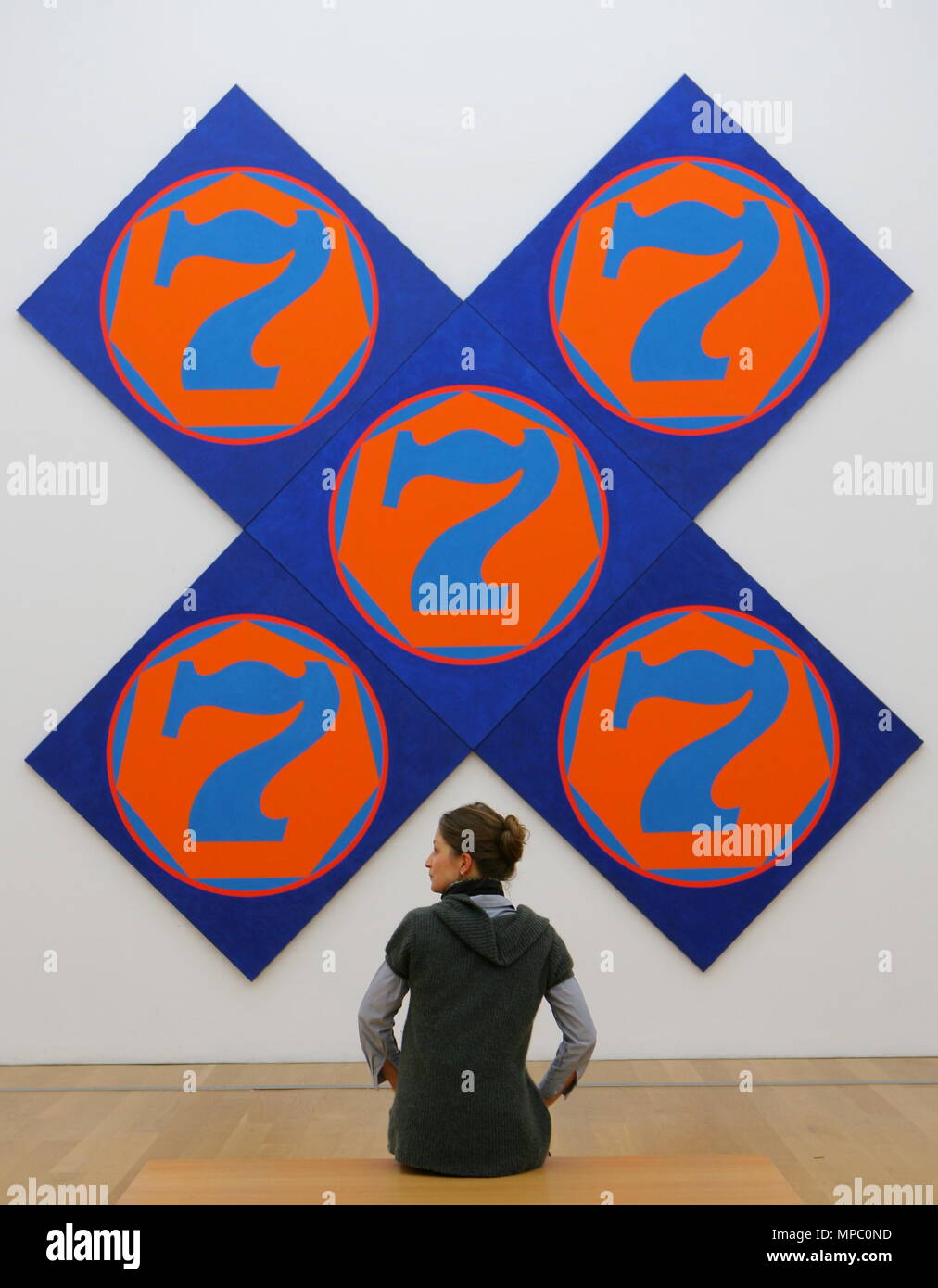 Wiesbaden, Germany. 18th Jan, 2008. A woman eyes the paintin 'The X-7' (1998) by US pop artist Robert Indiana in Wiesbaden, Germany, 18 January 2008. For the first time, the series 'Numbers' is exhibited in Europe. From 22 January through 18 May the museum puts paintings, graphics and sculptures on display in the exhibition 'Robert Indiana - The American Painter of Signs'. Credit: ARNE DEDERT | usage worldwide/dpa/Alamy Live News Stock Photo