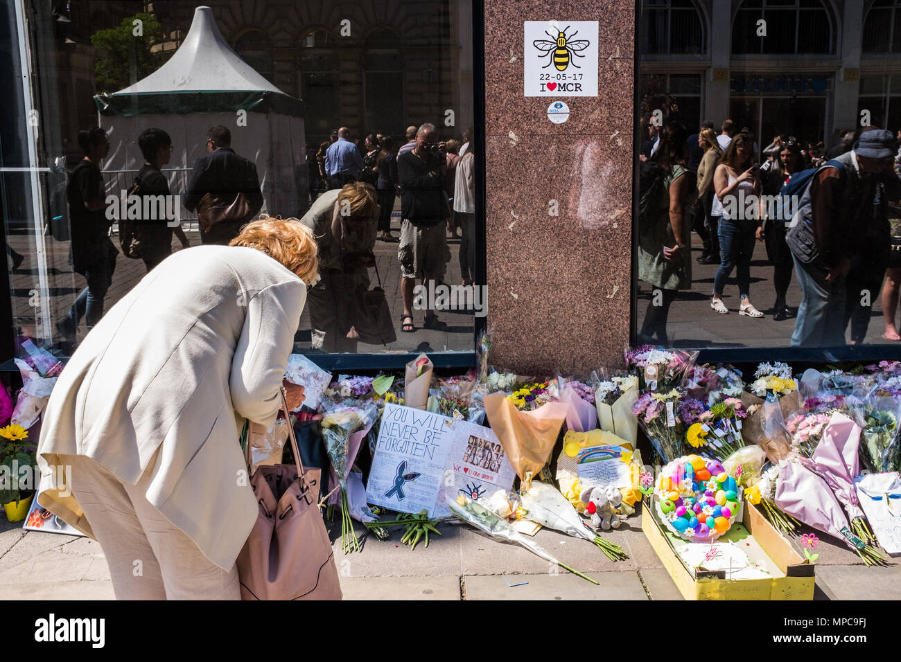 St Anne's Square, Manchester, UK. 22nd May, 2018. A woman reads messages in St. Anne's Square, Manchester remembering the victims of the Manchester Arena bombing on it's 1st anniversary. Credit: Ian Walker/Alamy Live News Stock Photo