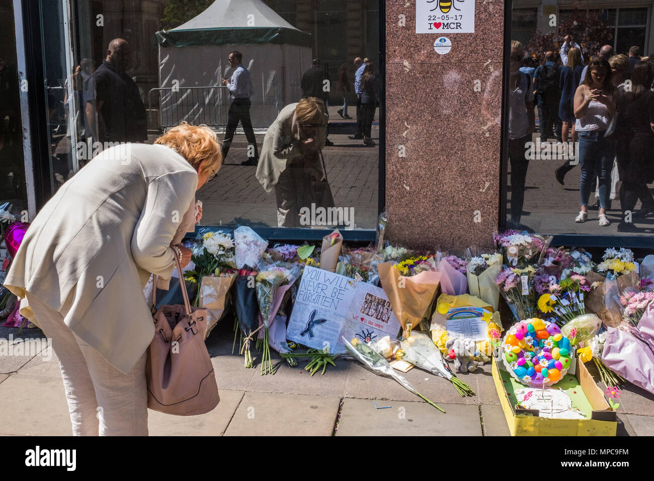 St Anne's Square, Manchester, UK. 22nd May, 2018. A woman reads messages in St. Anne's Square, Manchester remembering the victims of the Manchester Arena bombing on it's 1st anniversary. Credit: Ian Walker/Alamy Live News Stock Photo