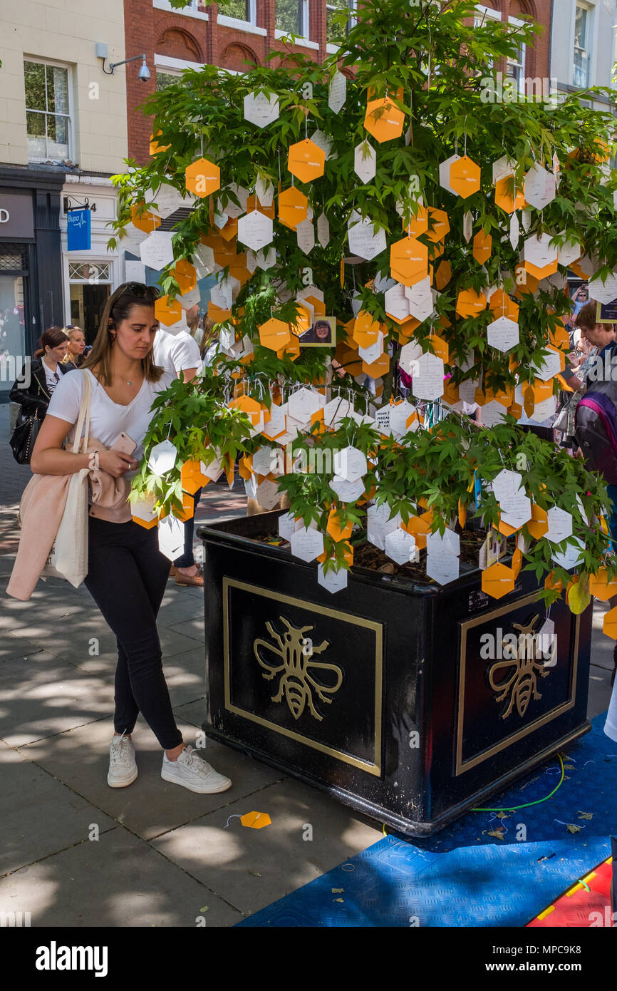 St Anne's Square, Manchester, UK. 22nd May, 2018. A woman reads messages at a memorial in St. Anne's Square, Manchester to commemorate the 1st anniversary of the Manchester Arena bombing. . Credit: Ian Walker/Alamy Live News Stock Photo