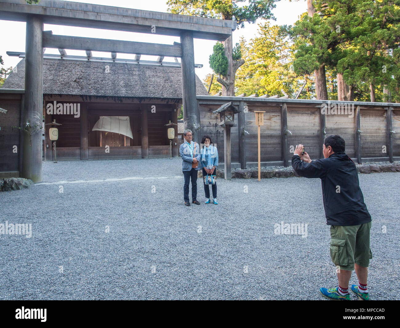 Man and woman being photographed in front of Goshoden main sanctuary entrance, Geku, Ise Jingu, Mie, Japan Stock Photo