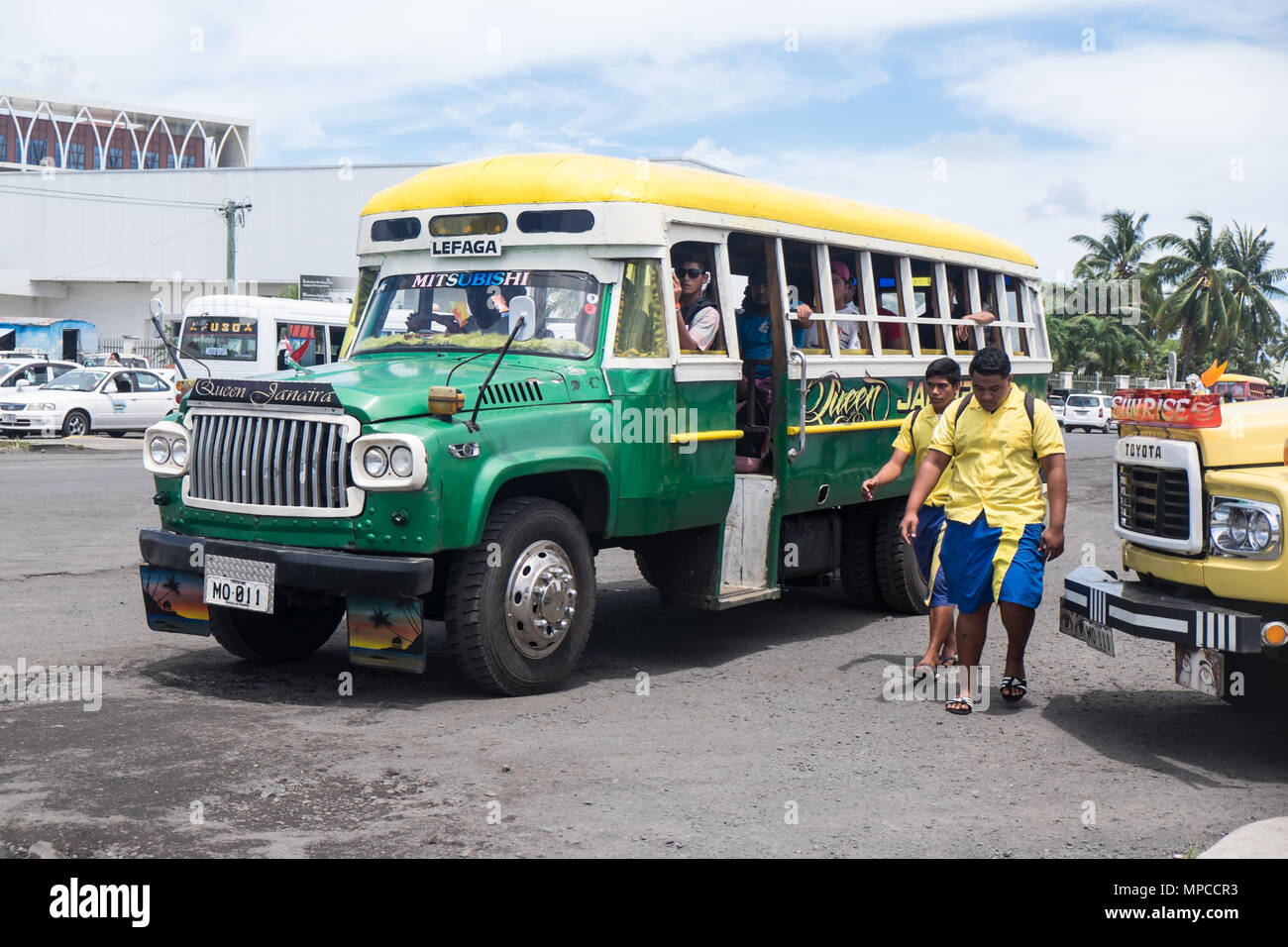 Apia, Samoa - October 30, 2017: People at Apia bus station, with colorful vintage buses on Upolu Island Stock Photo