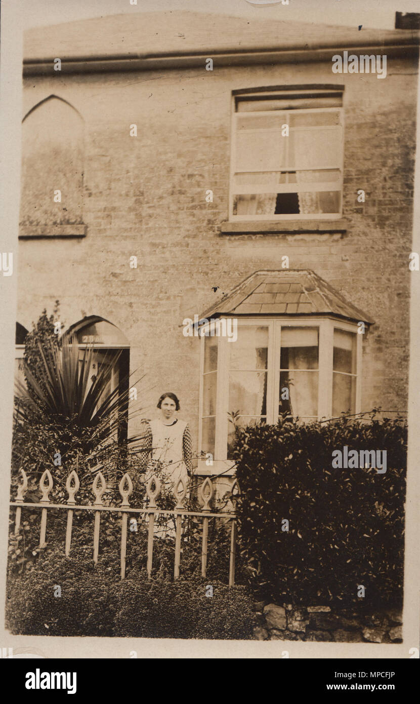 Vintage Photograph  Showing a Lady Posing In The Front Garden of Her Isle of Wight Home. Sign Above Door Reads 2 Broo??? Stock Photo