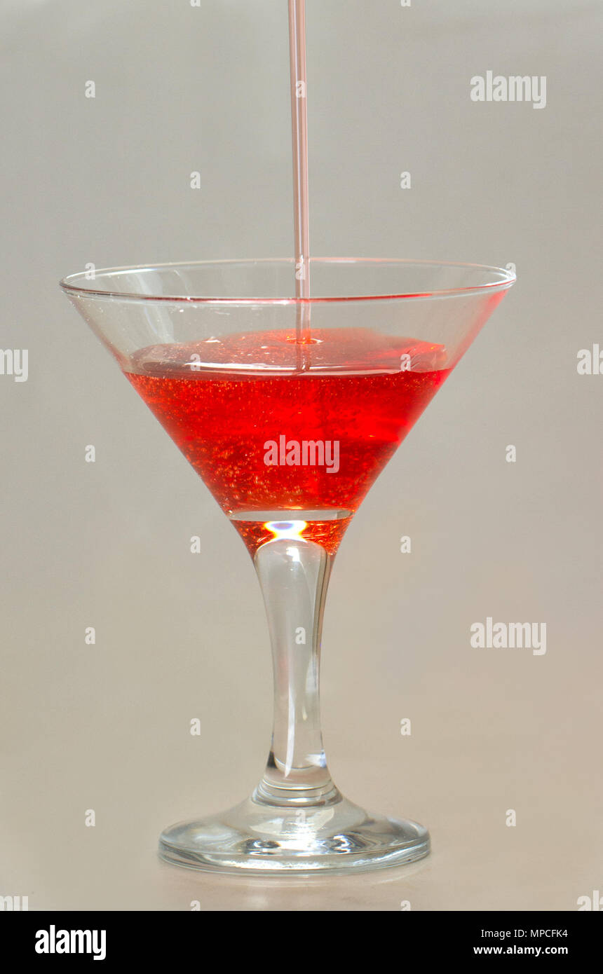 Drop of water falling in martini glass in purple tones Stock Photo - Alamy