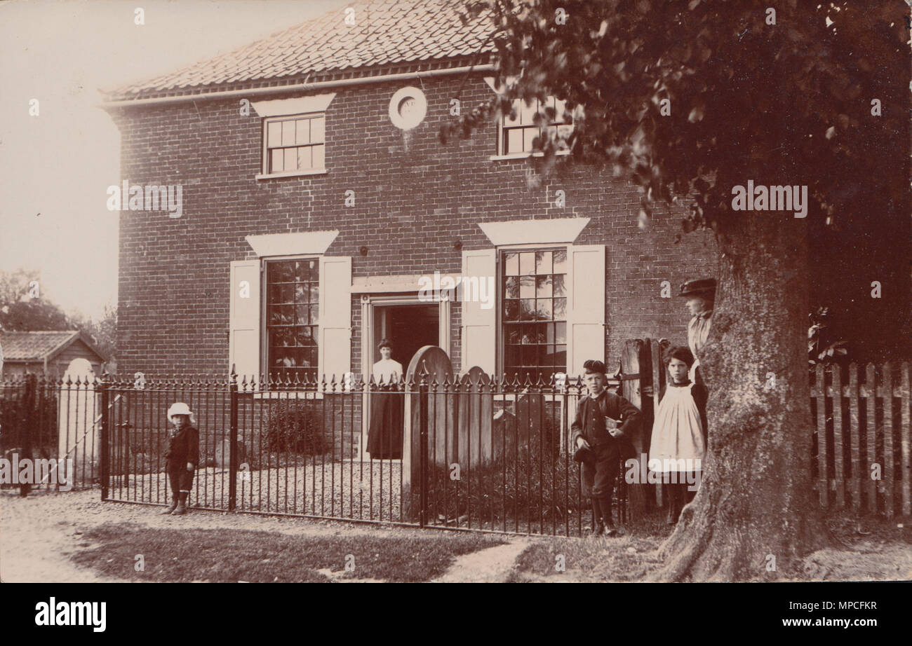 Vintage Edwardian Photograph of Adults and Children Posing at a House With Gravestones, Possibly a Vicarage, Stock Photo